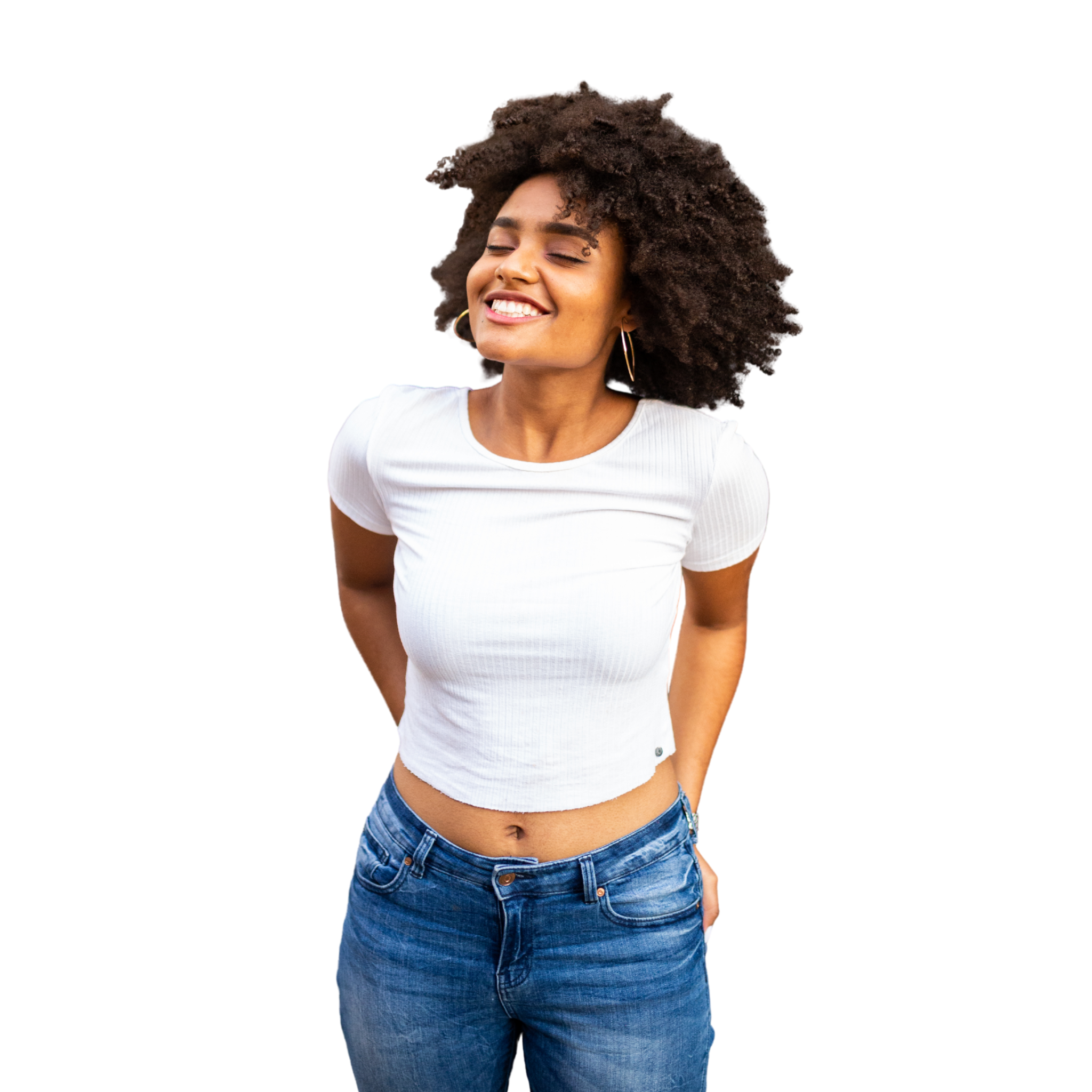 Happy woman wearing a white crop top and blue jeans, posing casually with a bright smile.
